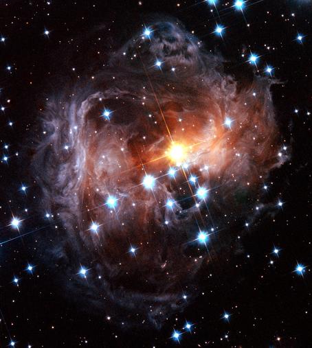 Colorful spiral dust clouds surround glowing central star