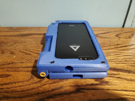 Closed side view of the folding dual pinephone case showing the charging and headphone jacks on one side as well as a torx deck screw hinge pin