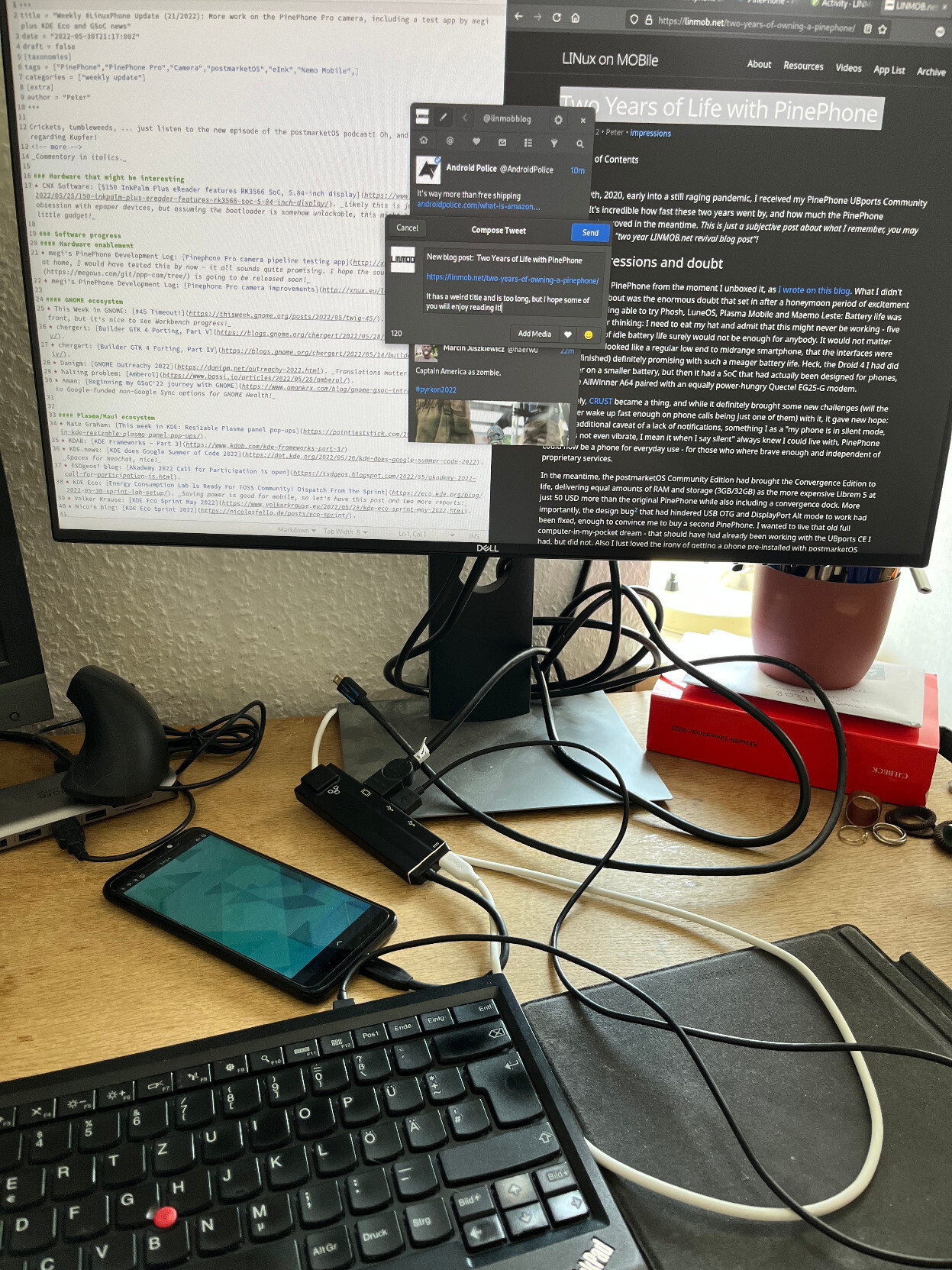 A PinePhone, connected to a monitor and a keyboard with track point, displaying a draft of a tweet to announce the same blog post on Twitter