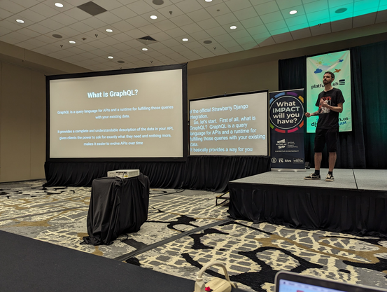 Thiago at the podium with a slide titled "What is GraphQL?"

"GraphQL is a query language for APIs and a runtime for fulfilling those queries with your existing data. It provides a complete and understandable description of the data in your API, gives clients the power to ask for exactly what they need and nothing more, makes it easier to evolve APIs over time"