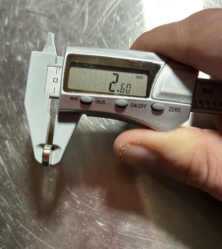 A small cylindrical magnet jn digital calipers reading 2.60