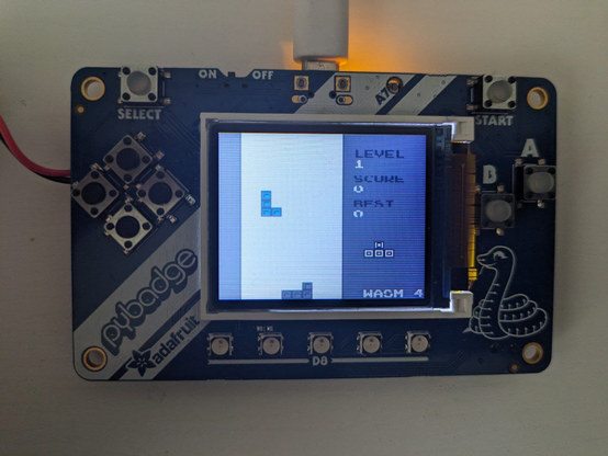 A photo of Adafruit PyBadge running tetris.