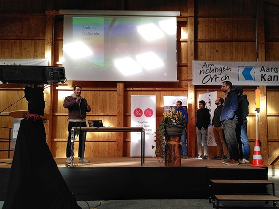 Photo of a hackathon team presenting a project on stage 
