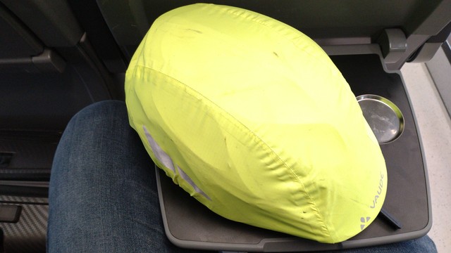 a bike helmet with bright yellow cover laying on a train table