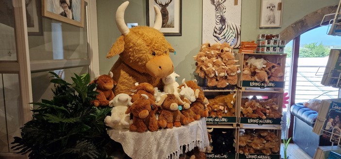 A mountain of cow plushie things, with an enormous one looking down on customers