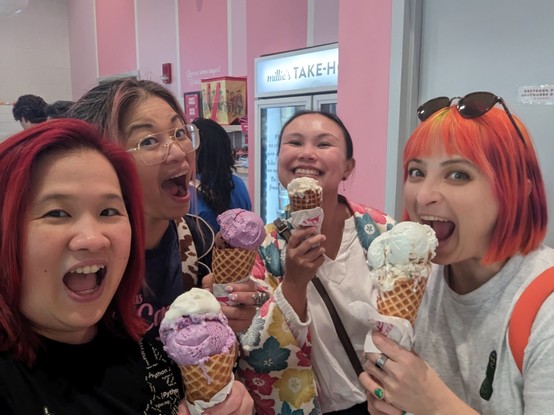 Group selfie 
4 women each holding ice cream in waffle cone
From left to right
Mariatta with purple ice cream
Georgie with purple ice cream
Cheuk with ice cream
Tereza with ice cream

Behind them is the inside store of Millie's Homemade Ice cream, pink colored walls