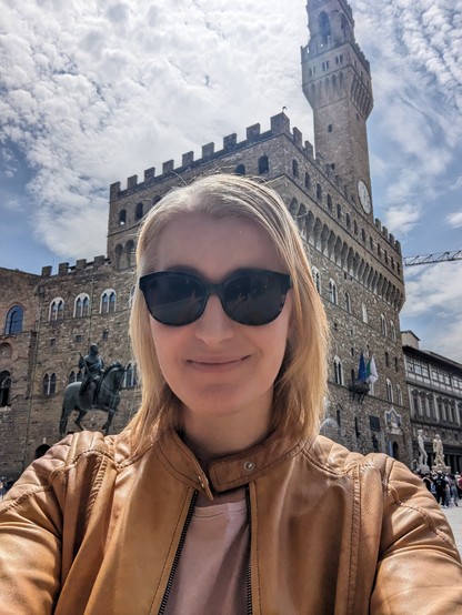 Selfie of a woman in front of the Uffizi Gallery in Florence, Italy.