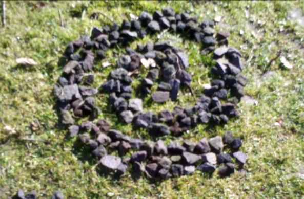 Stones laid out in a swirl on grasfield