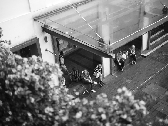 View from top of pedestrian crossing on a group of elderly people seated on a rainy day