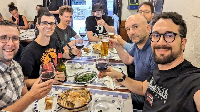 People posing in a restaurant with glasses of wine