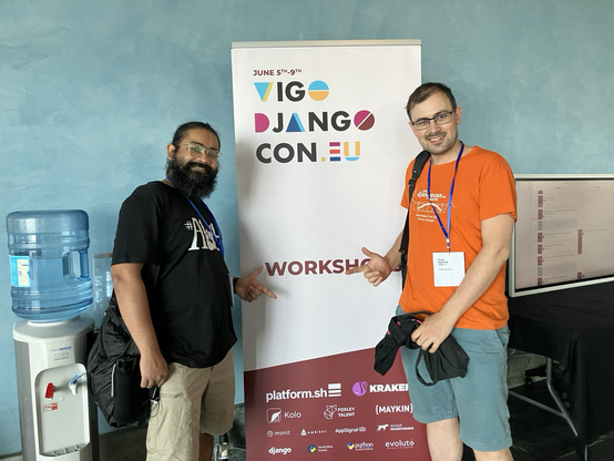 Saptak and Thibaud in front of the Vigo DjangoCon workshops banner