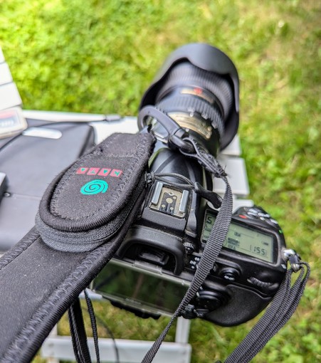 DSLR camera with strap. The strap has a small slimline zippered pocket/pouch down by the clip that is not that noticable if you aren't looking for it.