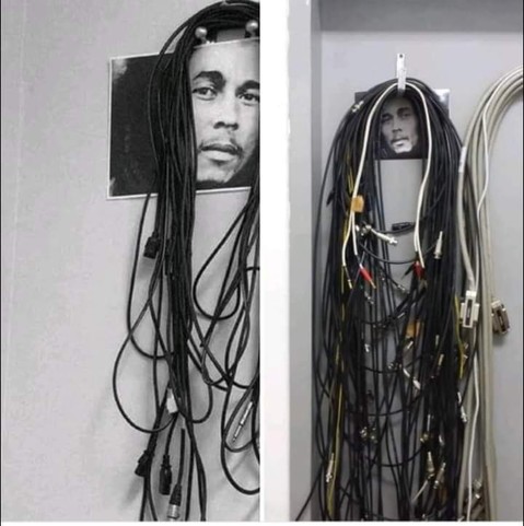 Cables colgando de un gancho con una foto de Bob Marley. Los cables parecen su pelo.