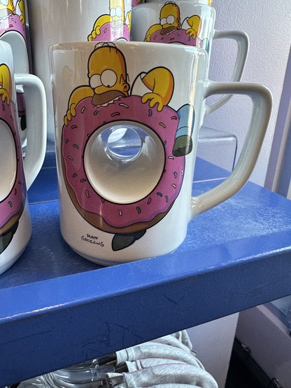 A homer simpson themed coffee mug with middle missing, painted as a giant donut