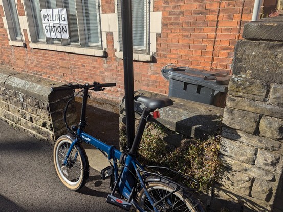 My little blue folding bike, parked up outside a polling station