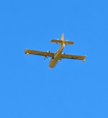 Blurry photo of a CL-415 water bomber from below. You can make out the two props and the seam line for the doors in the nose.