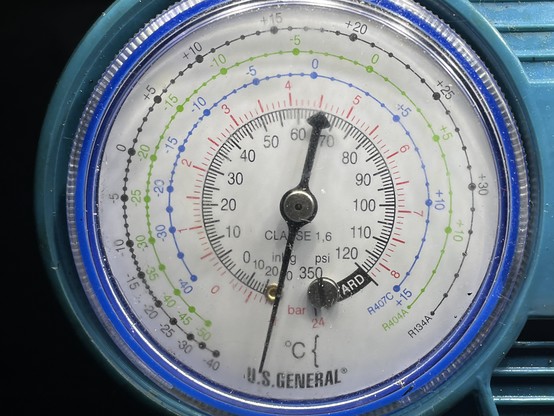 An air conditioning gauge, with the needle reading 1 bar of vacuum. 
