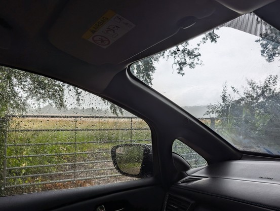 A photograph of me trying to do outside work whilst it is tipping down. I have taken shelter in my car.