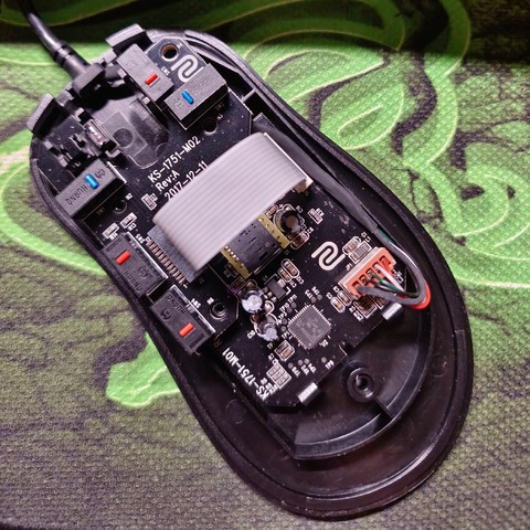A BenQ Zowie EC1-B mouse with the top disassembled, revealing the circuit board inside. 