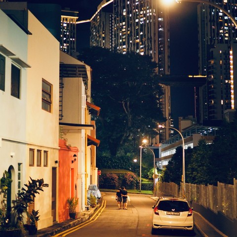 Back lane with shop houses in foreground and high rise residential apartments in the background. 