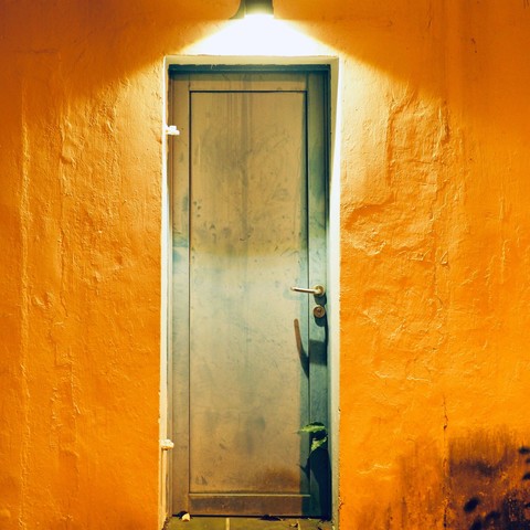 A wooden door under a spotlight. 