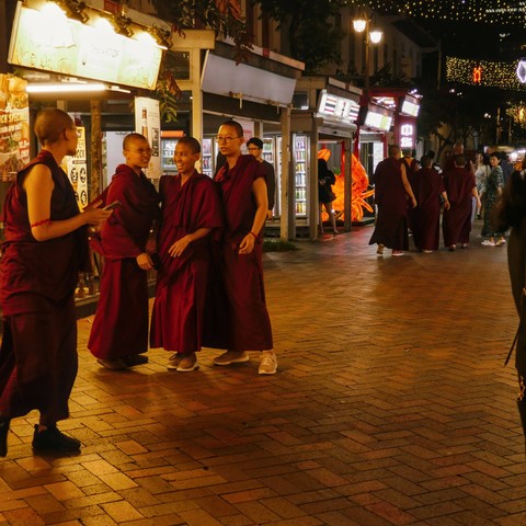 Tibetan novices in their maroon attire getting ready for a photo at a walking street in Chinatown 