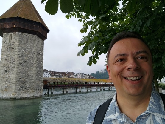 A selfie with myself on the right side below a tree. On the left side there is the famous water tower of Lucerne. In the center is the Kappell bridge crossing the river Reuss.