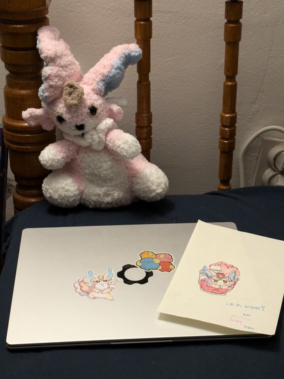 A picture of a homemade Purrely plush (Yu-Gi-Oh monster), Purrely drawing on a birthday card and a laptop with 2 stickers, one being Purrely, the other being 4 sheep tokens (also a Yu-Gi-Oh card)