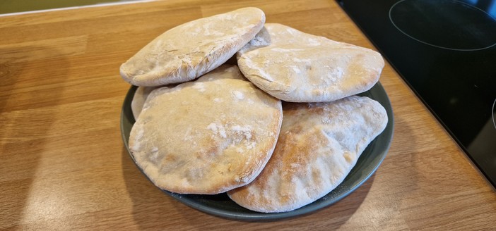 A plate of 6 freshly baked pitta breads.