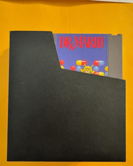 This is Dr. Mario, an original NES cartridge game in its black vinyl sleeve.