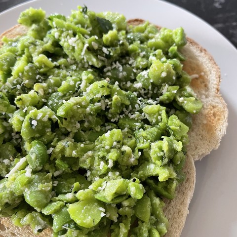 Broad bean bruschetta: roughly mashed broad beans with a little mint and olive oil, served on toast with a sprinkling of vegan Parmesan on top