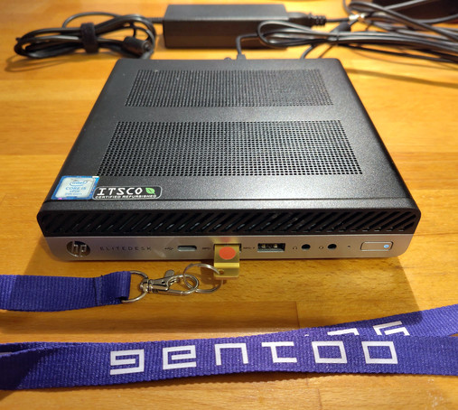Thin Client Computer, der von einem USB Stick gebootet wird. Am USB Stick ist ein violettes Band mit Gentoo Schriftzug. 