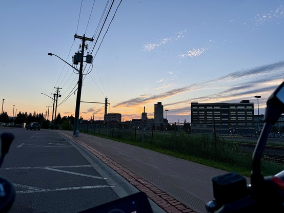 sunrise over the tracks, downtown Moncton behind the Avenir Centre. Handlebars partly in view.