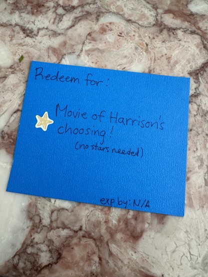 Paper card with writing: “redeem for: Movie of Harrison’s choosing!”