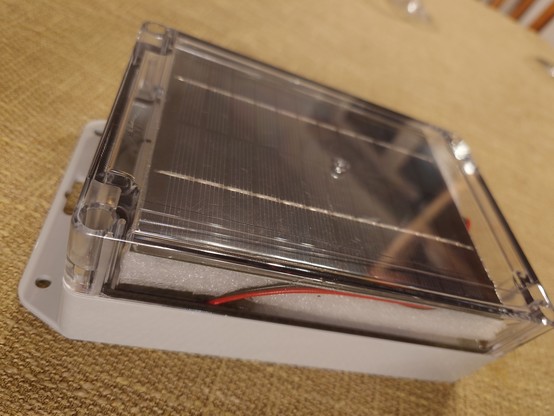 Box with transparent lid showing solar panel underneath