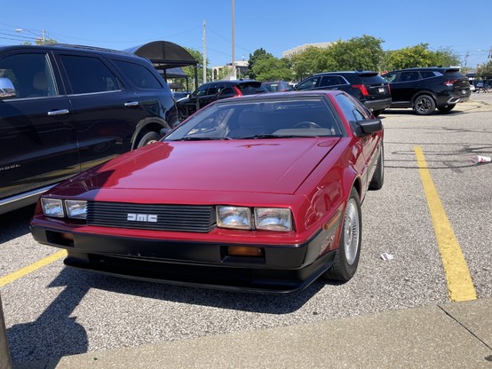 Front view of a DeLorean in a parking lot.