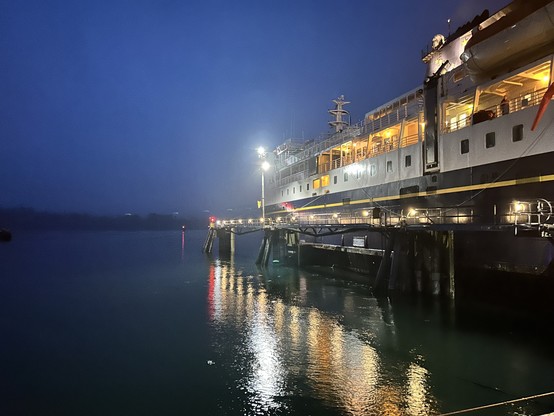 Ferry tied up at dock with lights on