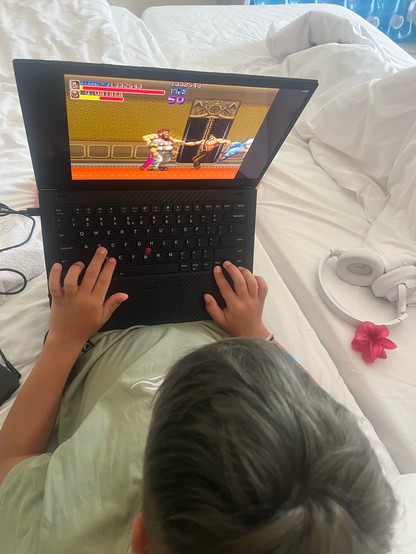 Kid playing Final Fight on a laptop