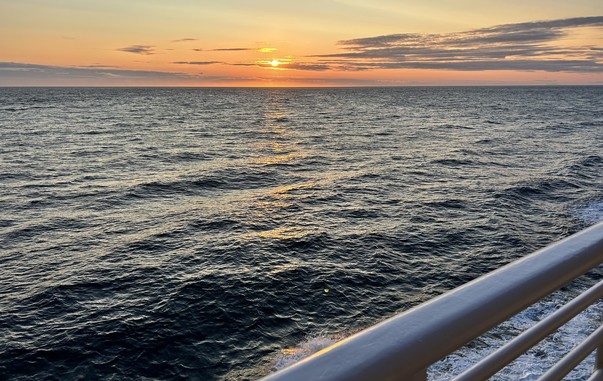 Setting sun across open ocean from the ferry deck