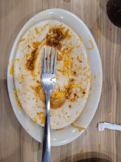 An empty plate, that was formerly full of Skyline chili
