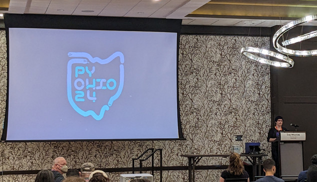 PyOhio logo on a projector slide with the speaker, Kattni, at the podium 