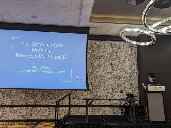 PyOhio stage. Elaine Wong at the podium on the right.
Presentation slide on the left. Title: So I got some code working... Now how do I share it?