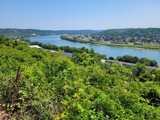 A picturesque shot of a bend in the Ohio River with lush greenery on each bank 