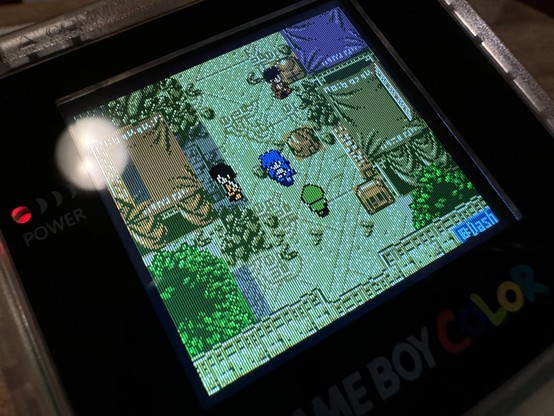 A close up of a Gameboy Color’s screen. The display shows a blue character in a village in a top down view. Some other characters are visible as well. 

It looks like the pixels are visible due to very thin vertical black lines on the screen which mimic the spacing between the original screen’s pixels.