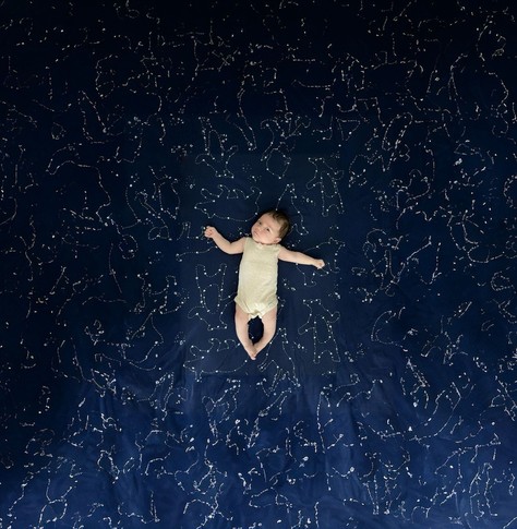 The same image as the previous one, but the blue with constellations has been extended many times the size of the baby. The baby looks like she’s floating in a vast expanse of stars. The AI generated constellations farther away from her don’t take on any specific shape, but when looking at the whole picture they don’t stand out. 