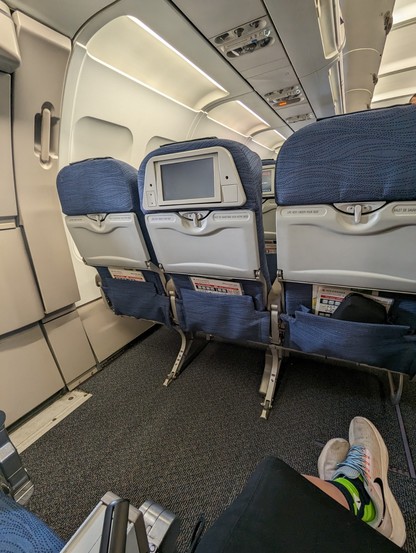 Photo inside and airplane showing the ample space in the exit row