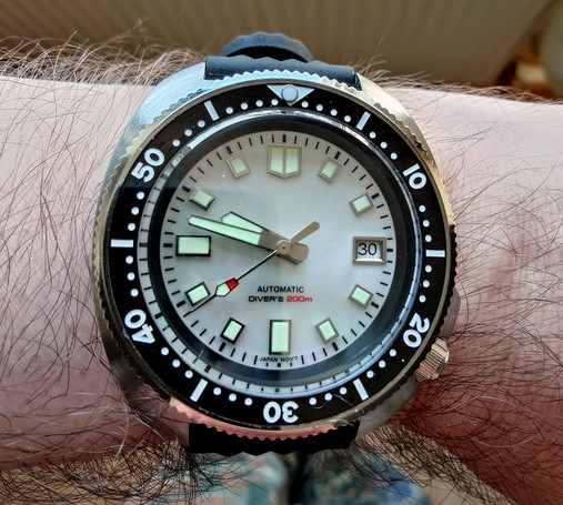 Tandorio analog watch with automatic winding. Perly-white watchface and luminous indices and hands. A black rotatable minute ring surrounding it.  