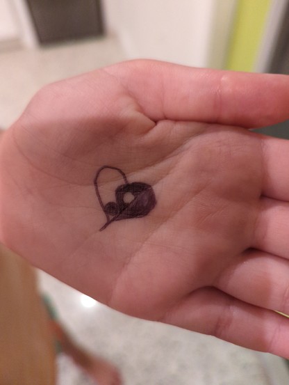 A ying-yang heart shape in ink on my daughter's hand.