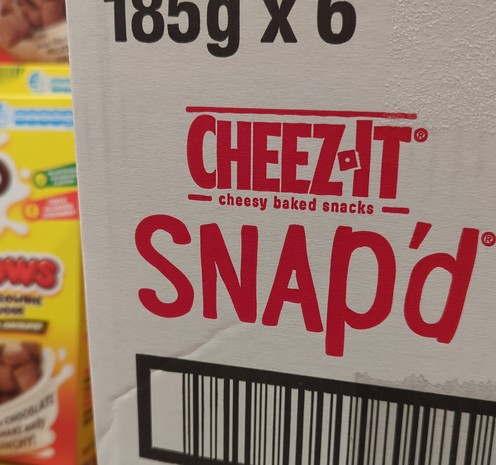 Close-up of a case of boxes of Snap'd crackers, in a supermarket.
