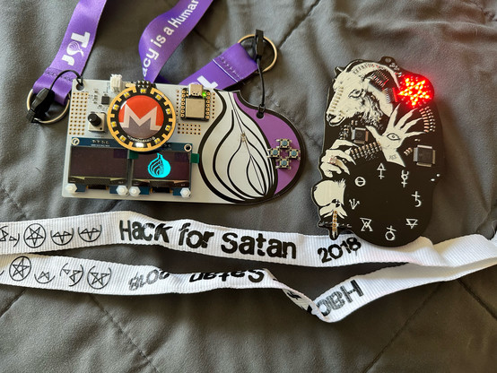 Two DEF CON electronic badges. One for Tor and one for Hack for Satan. 